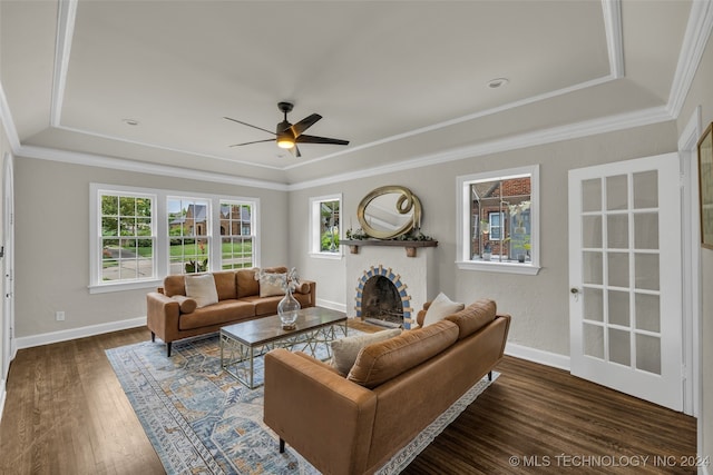 living room featuring a wealth of natural light, ceiling fan, a fireplace, and dark wood-type flooring