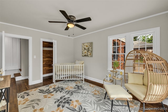 bedroom with ornamental molding, a closet, dark hardwood / wood-style floors, and ceiling fan