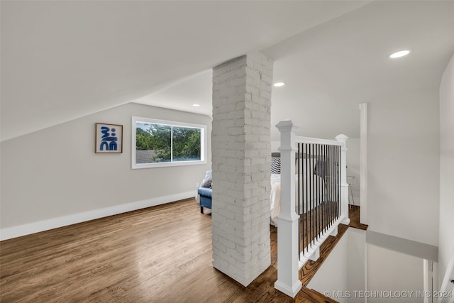 interior space featuring ornate columns, vaulted ceiling, and hardwood / wood-style floors