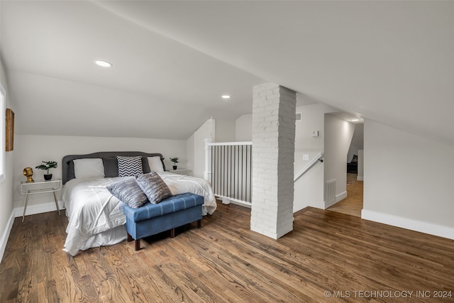 bedroom with decorative columns, vaulted ceiling, and dark hardwood / wood-style flooring