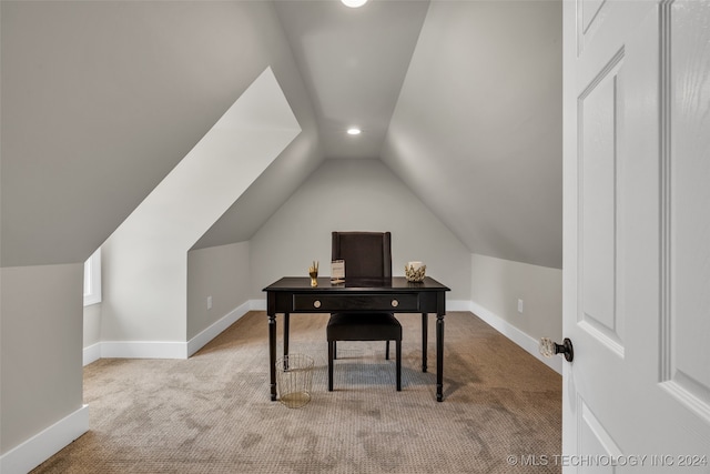 home office with vaulted ceiling and light colored carpet