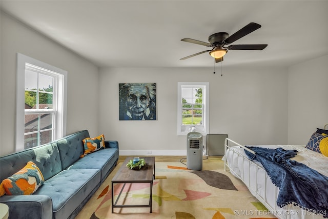 bedroom with light hardwood / wood-style floors, multiple windows, and ceiling fan