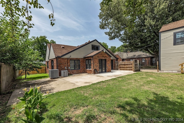 back of house with central AC unit, a patio area, and a yard