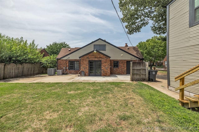 rear view of house with a yard, central AC, and a patio area