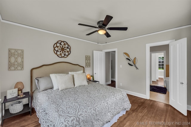 bedroom with crown molding, dark hardwood / wood-style flooring, and ceiling fan