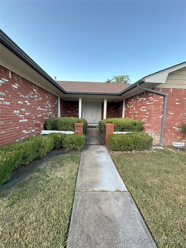 property entrance featuring a lawn