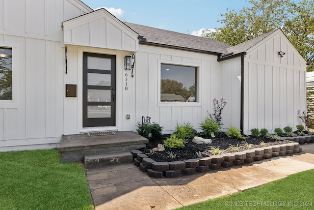 property entrance with a lawn