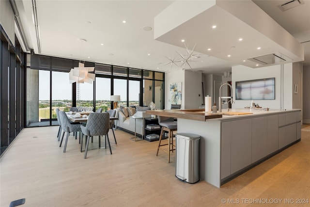 kitchen featuring a wall of windows, light hardwood / wood-style floors, and gray cabinets