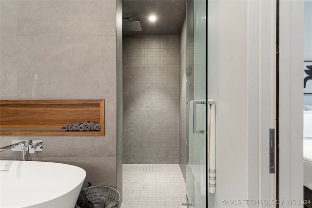 bathroom with independent shower and bath, tile walls, and tile patterned floors