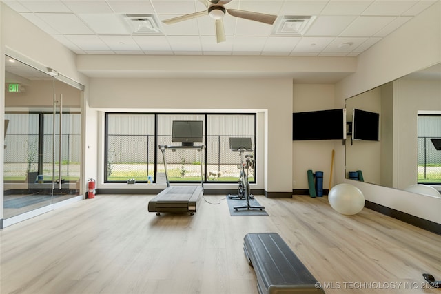 workout room with ceiling fan, a drop ceiling, and wood-type flooring