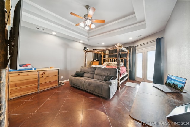 bedroom featuring dark tile patterned flooring, a tray ceiling, ceiling fan, french doors, and ornamental molding