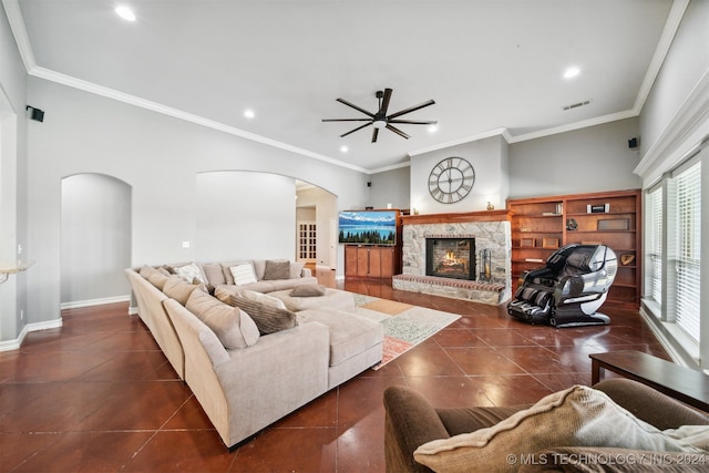 tiled living room with crown molding, a stone fireplace, and ceiling fan