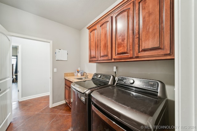 clothes washing area with separate washer and dryer, cabinets, sink, and dark tile patterned floors