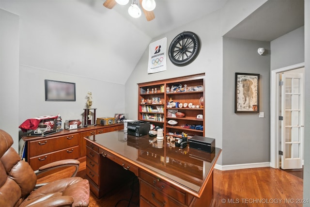 office featuring ceiling fan, vaulted ceiling, built in desk, and hardwood / wood-style floors