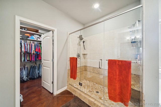 bathroom with a shower with door and tile patterned floors