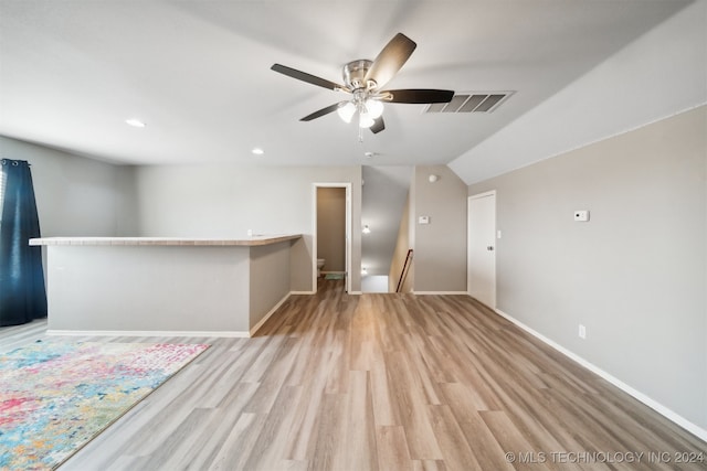 spare room featuring light hardwood / wood-style flooring, lofted ceiling, and ceiling fan