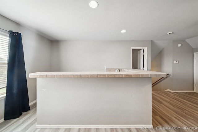 kitchen featuring light wood-type flooring and tile countertops