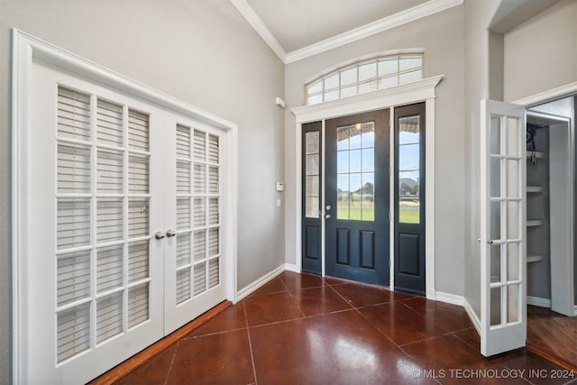 entrance foyer with ornamental molding, dark tile patterned flooring, and french doors