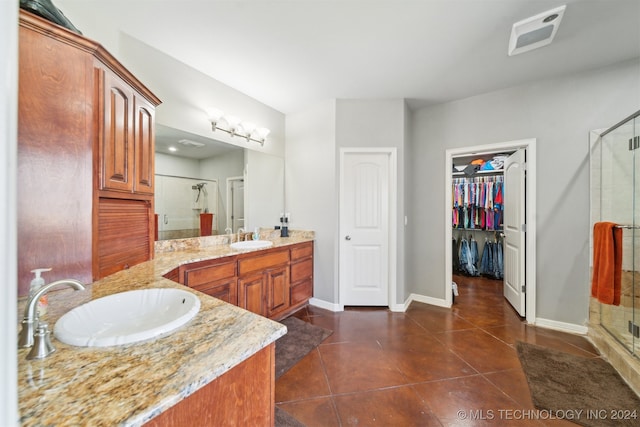 bathroom featuring tile patterned flooring, walk in shower, and vanity