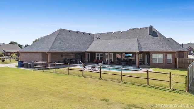 exterior space featuring a patio, a yard, and a fenced in pool