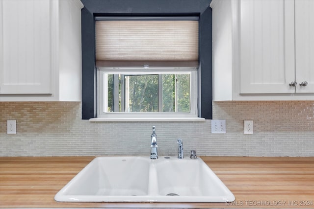 kitchen with white cabinetry, tasteful backsplash, and sink