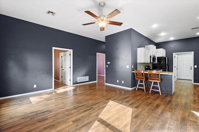 interior space featuring a ceiling fan, wood finished floors, and visible vents