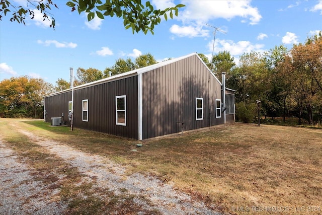 view of side of property with a yard and central AC unit