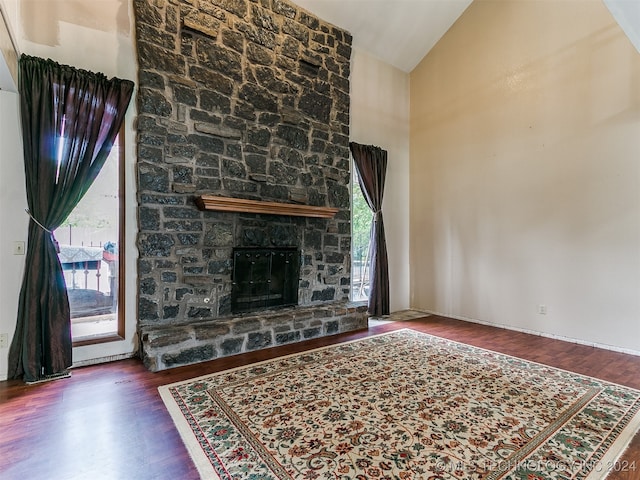 living room with high vaulted ceiling, a fireplace, and dark hardwood / wood-style flooring