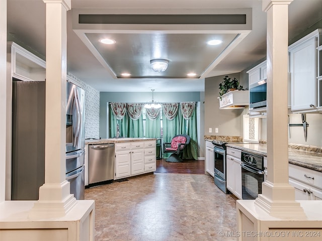 kitchen with white cabinets, a tray ceiling, ornate columns, and black appliances