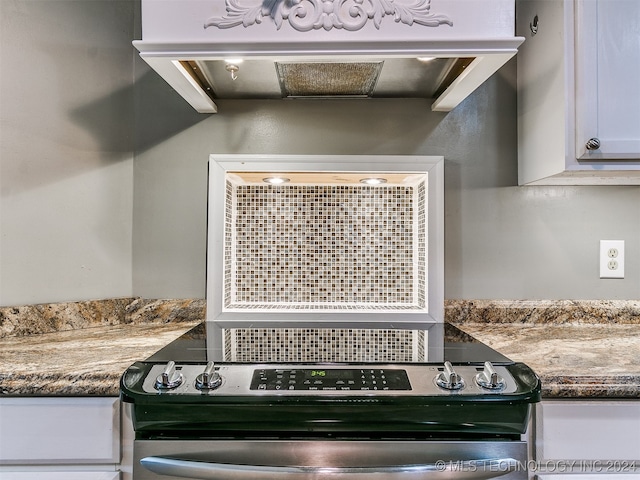 room details with stainless steel electric stove and white cabinets