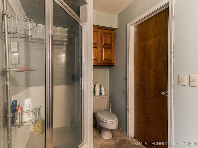 bathroom with a shower with door and toilet