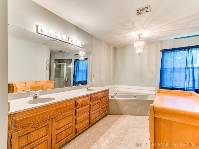 bathroom with an inviting chandelier, shower with separate bathtub, and vanity