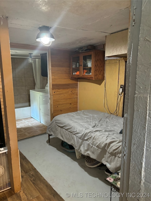 bedroom featuring separate washer and dryer and hardwood / wood-style floors