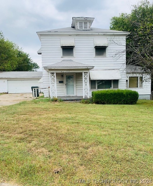 view of front of home with an outbuilding, a garage, and a front yard