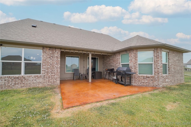 rear view of property with a yard and a patio area