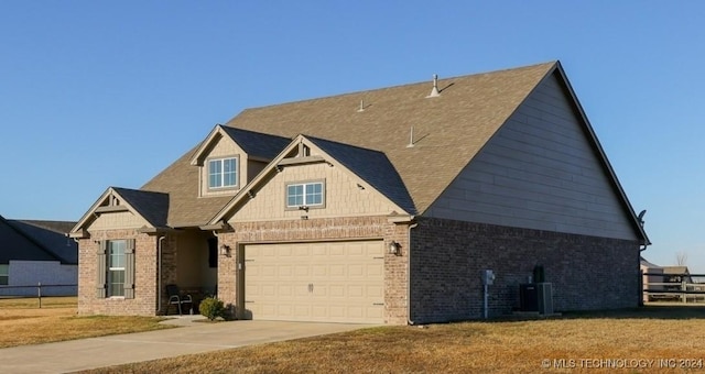 view of front of house with central AC unit, a garage, and a front lawn