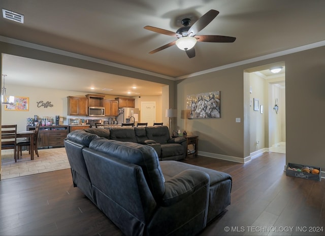 living room with ceiling fan, wood-type flooring, and ornamental molding