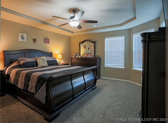 bedroom with carpet floors, a tray ceiling, and ceiling fan