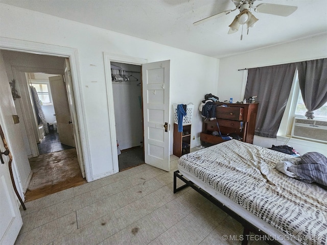 bedroom featuring multiple windows, light hardwood / wood-style floors, ceiling fan, and a closet