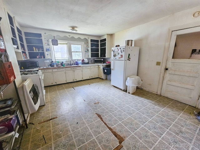 kitchen with white appliances, white cabinetry, and sink