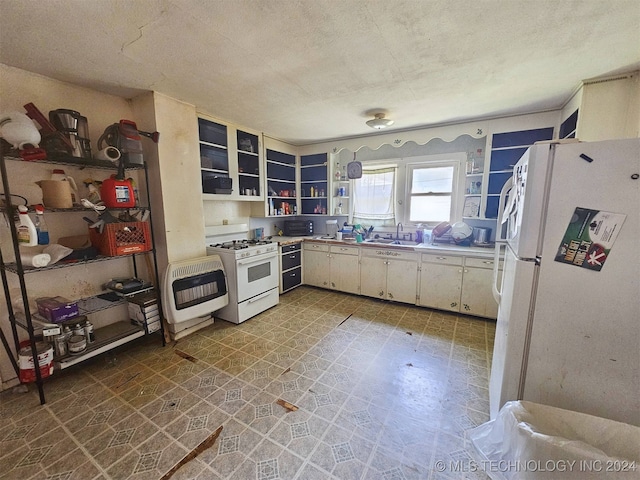 kitchen with white cabinets, sink, white appliances, heating unit, and a textured ceiling