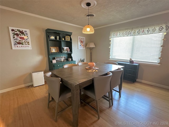 dining area featuring a textured ceiling, light hardwood / wood-style floors, and crown molding