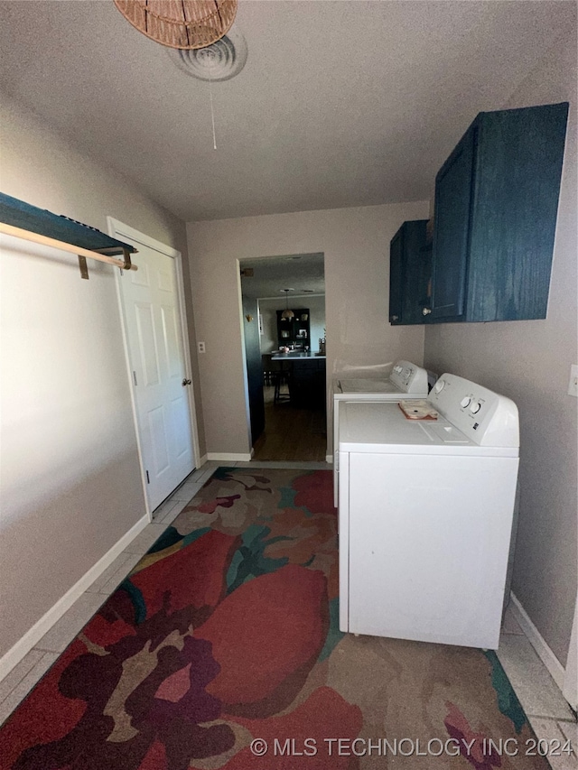 laundry room with carpet, cabinets, a textured ceiling, and washing machine and clothes dryer