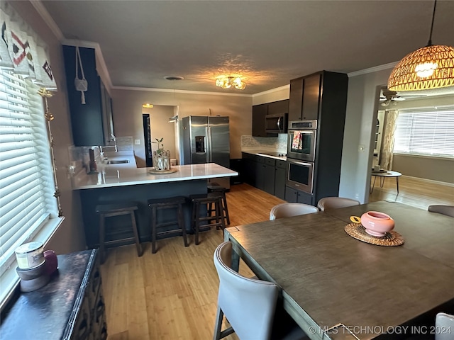 dining area featuring sink, crown molding, and light hardwood / wood-style floors