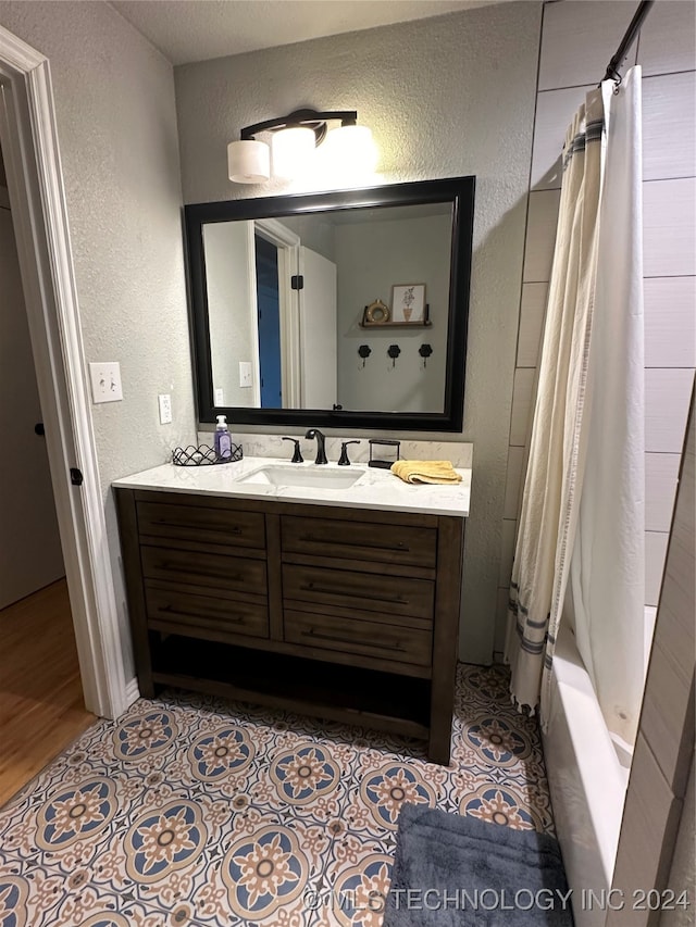 bathroom with shower / bath combo, hardwood / wood-style floors, and vanity