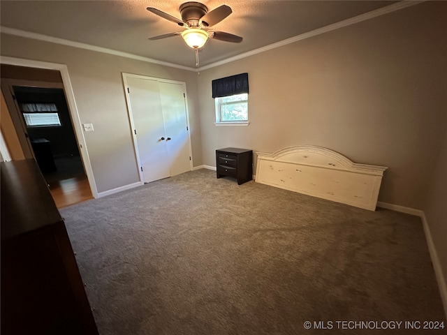 unfurnished bedroom with carpet, crown molding, ceiling fan, and a closet