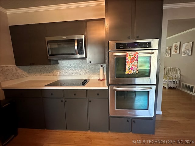 kitchen with hardwood / wood-style flooring, appliances with stainless steel finishes, ornamental molding, and decorative backsplash