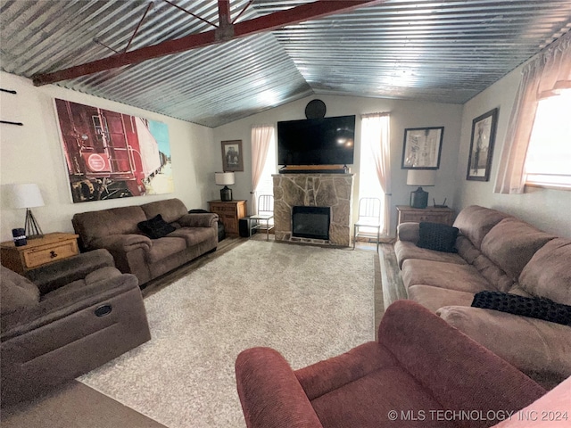 carpeted living room with a fireplace and vaulted ceiling