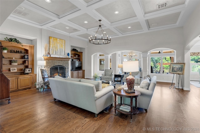 living room featuring coffered ceiling, dark wood-type flooring, a fireplace, beamed ceiling, and a notable chandelier