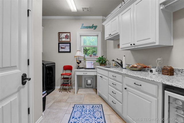 kitchen with white cabinets, wine cooler, light tile patterned flooring, sink, and ornamental molding